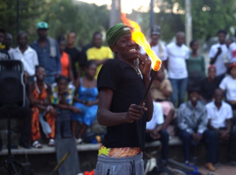 A performer pretends to get burned after attempting to put a lit torch in his mouth. Photo by Onz Chéry/ The Haitian Times